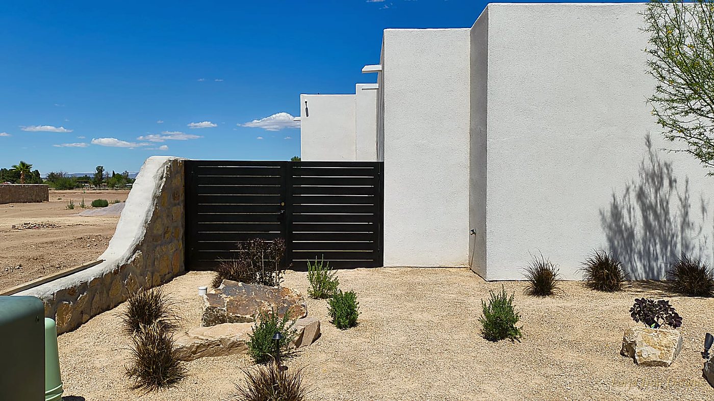 Hand-laid quarry fieldstone wall and modern iron driveway gate
