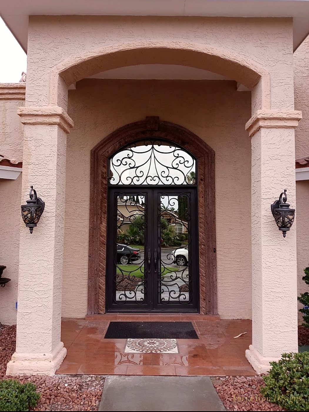 Ornate Scrollwork Iron Doors with Arched Transom
