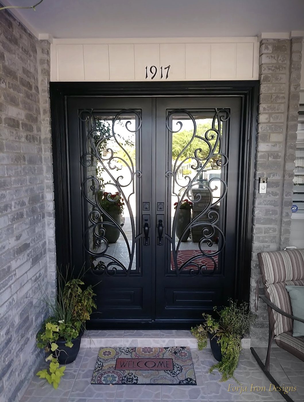 Black Scrollwork Iron Doors on Brick Home
